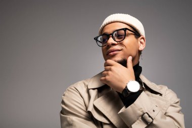 Moda kıyafetleri içindeki genç adam kendine güvenerek, tarzını ve kişiliğini sergiliyor..