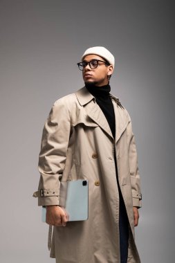 Tabletli kendine güvenen genç bir adam bir stüdyoda tarzını gösteriyor..