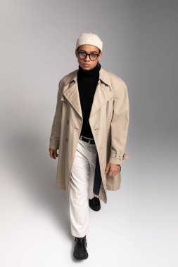 Yakışıklı genç bir adam, kendine güveni olan modaya uygun bir kıyafet giyerek kendine has tarzını sergiliyor..