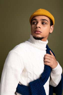 Moda kıyafetleri içindeki genç adam kendine güvenerek benzersiz tarzını ve kentsel yeteneğini vurguluyor..