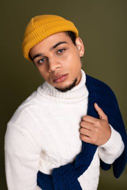 Tarz sahibi genç bir adam modern bir kış görüntüsü sergiliyor. Kendine güveni ve cazibesiyle.