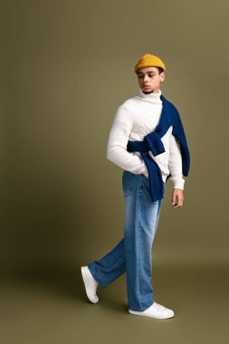 Yakışıklı genç adam, rahat bir havası olan, modaya dikkat çeken modern bir kıyafetin içinde özgüvenle poz veriyor..