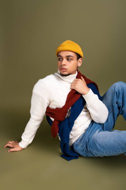 Yakışıklı genç adam zarif bir şekilde şık giyiniyor, kendine güvenini ve tarzını gösteriyor..