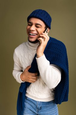 Telefonda konuşurken rahat bir süveter giyen şık bir genç adama parlak bir gülümseme..