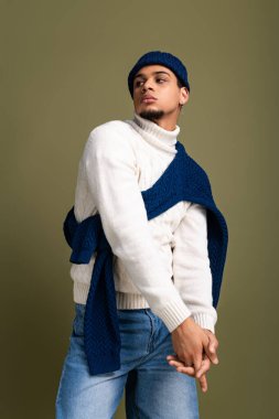 Samimi giyinen genç adam, modern kış modasını ön plana çıkarırken kendinden emin poz veriyor..