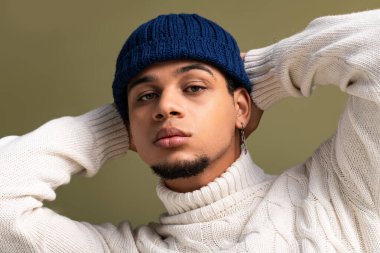 Kendine güveni tam bir genç adam gösteriş yapıyor. Elleri başının arkasında, rahat bir ortamda..