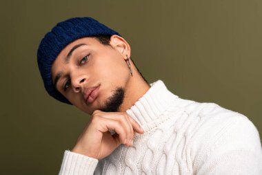 Yakışıklı bir genç adam modaya uygun bir şekilde poz veriyor, zahmetsiz bir stil ve cazibe yayıyor..