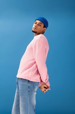 Yakışıklı genç bir adam şık ve canlı renkler içinde rahat bir şekilde poz verir..