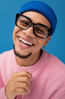 Moda gözlük takan yakışıklı genç adam ve renkli bir bere, neşe ve güven saçıyor..