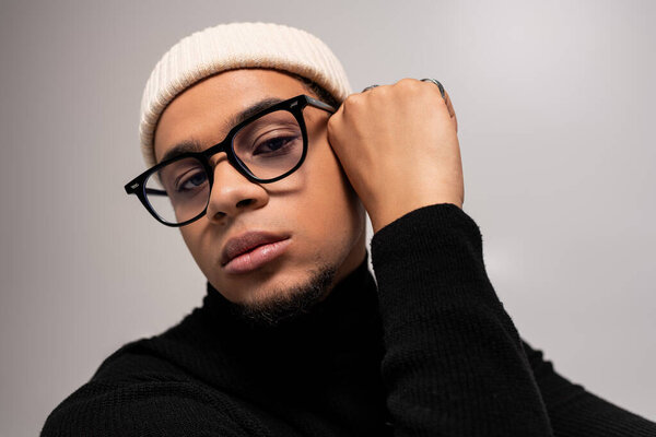 Молодой человек демонстрирует свой модный взгляд с изяществом и уравновешенностью в гладкой обстановке.