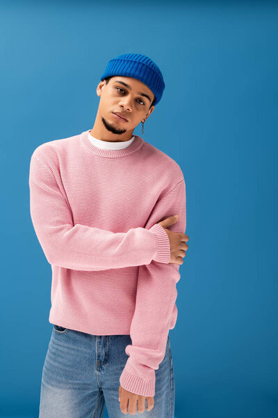 Красивый молодой человек уверенно позирует в стильной одежде, отражая современные модные тенденции.