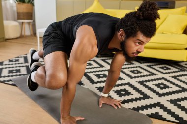 Evde kıvırcık saçlı, odaklanmış ve kararlı atletik bir Afrikalı Amerikalı..