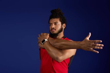 Odaklanmış bir Afrikalı Amerikalı, parlak mavi bir ortamda çalışırken kollarını uzatıyor..
