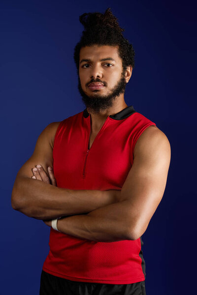 Strong African American man with curly hair and a beard confidently poses while working out.