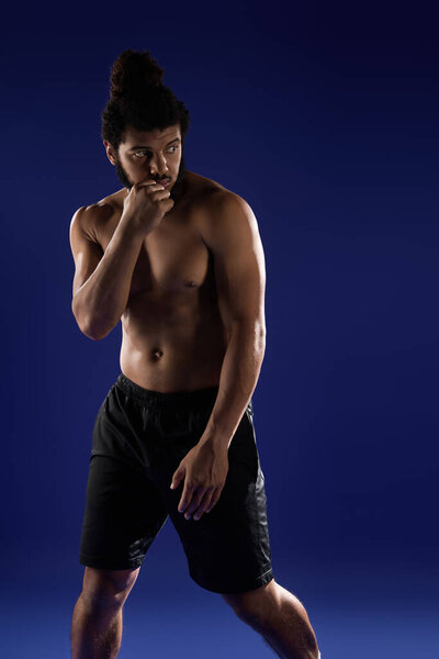 Самоотверженный черный человек интенсивно тренируется, демонстрируя силу на синем фоне.