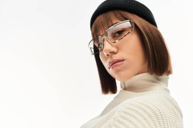 Moda kıyafetleri içinde genç bir kadın poz verirken kendine güven yayıyor, eşsiz tarzını vurguluyor..