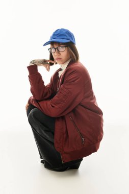 Güzel, genç bir kadın, bir stüdyoda çömelirken eşsiz moda anlayışını sergiliyor..