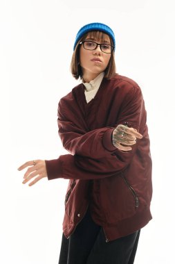 Tarz sahibi genç bir kadın, modaya uygun kıyafetler giyerken kendine güvenerek poz verir ve eşsiz bir şehir havası yakalar..