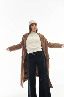 Çekici genç kadın, temiz ve parlak bir zemin karşısında şık kış modasını sergiliyor..