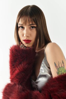 Zarif genç bayan zarif kıyafetini ve yumuşak ışıkta eşsiz dövmesini vurguluyor..