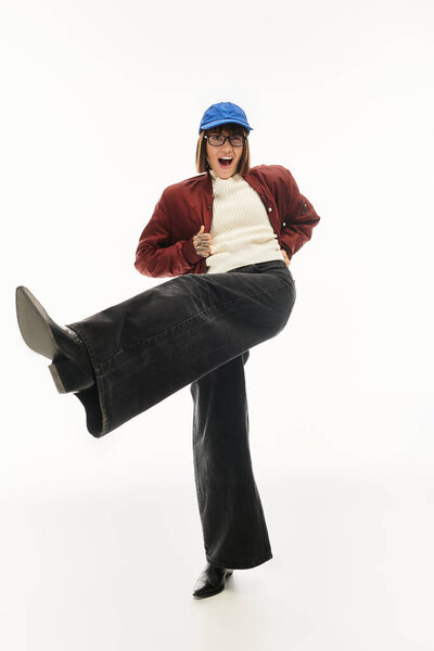 Молодая женщина демонстрирует свою яркую личность и уверенность через моду в студии.