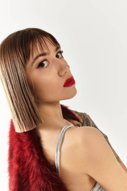 Genç bir kadın zarif pozlar veriyor, şık kıyafetini ve kendine güvenen cesur makyajını sergiliyor..