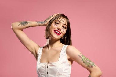 Güzel bir genç kadın kendine güvenerek poz verir, şık kıyafetler giyer, neşeli makyaj aksanları yapar..