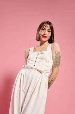 Şık genç bir kadın canlı pembe bir duvara karşı güven içinde poz verir..