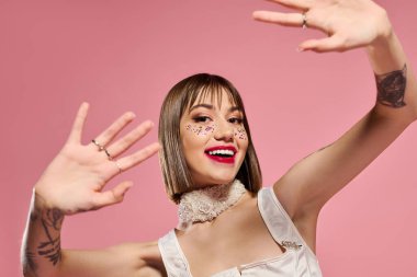 Şık bir genç kadın neşeli hareketler ve cesur makyajla neşeli ruhunu ifade eder..