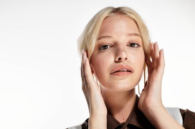 Şık genç sarışın kadın beyaz bir stüdyoda poz veriyor, kış modası eğilimleri sergiliyor..