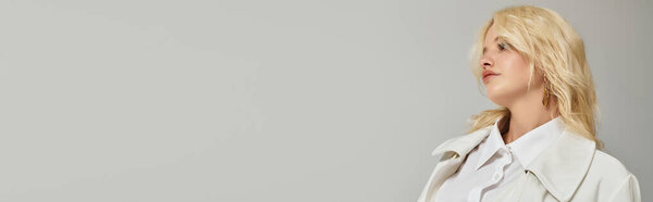 Блондинка демонстрирует модный зимний наряд в яркой студии, запечатлев шикарный стиль, баннер