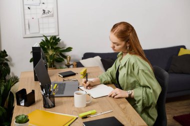 Güzel, genç bir kadın, bir masanın üzerinde oturuyor. Yazıya dalmış, ev konforuyla çevrili..