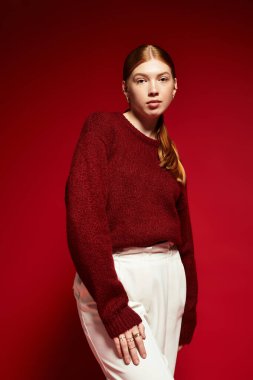 Canlı kızıl saçlı genç bir kadın, sıcak bir süveter giyer ve kış havasını uyandırır..