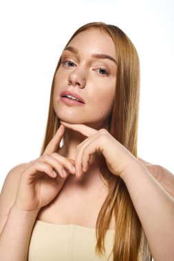 Uzun saçlı güzel bir genç kadın cazibesini ve zarafetini göstererek yumuşak poz verir..