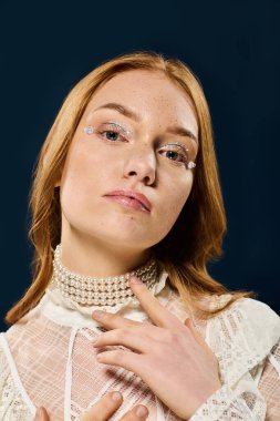 Genç bir kadın zarif pozlar veriyor, eşsiz stilini inci detaylar ve yumuşak makyajla sergiliyor..