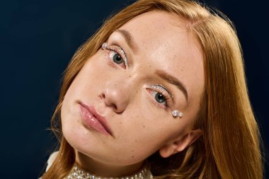 Işıl ışıl cildi ve incileri olan genç bir kadın büyüleyici özelliklerini zarafetle vurgular..