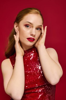 Güzel genç bir kadın, çarpıcı tarzını zengin bir kırmızı ayara güvenerek sergiliyor..