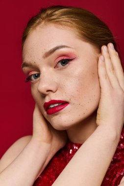 Güzel bir genç kadın makyaj sanatını ve canlı stilini bir stüdyo ortamında sergiliyor..