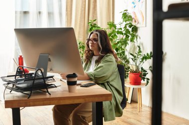 Beyaz perçemli ve mavi gözlü bir kadın canlı bir evde bilgisayarına odaklanıyor..