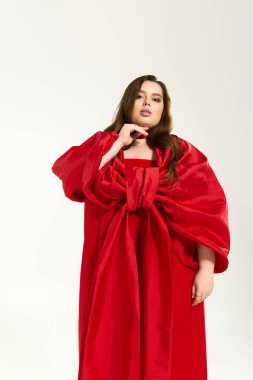 Büyük yaylı kırmızı elbiseli genç bayan kış tatili neşesinin tadını çıkarıyor..