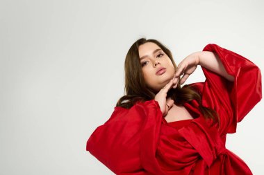 Canlı kırmızı kıyafetli iri yarı genç bir kadın kış tatili için neşesini paylaşıyor..