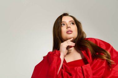 Kırmızı elbiseli neşeli, iri yarı genç kadın kış tatilini şenlikli bir ruhla kutluyor..