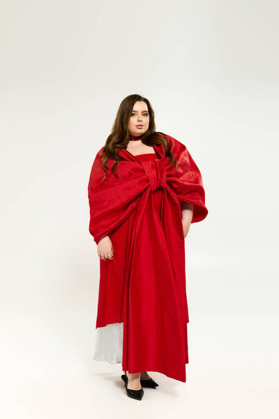 A young woman in a bright red outfit with a bow celebrates the winter season.