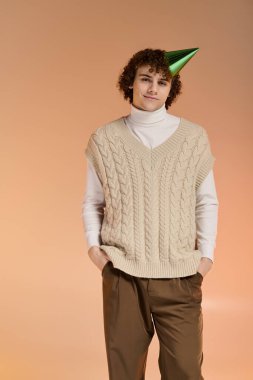 Genç çocuk bir stüdyoda doğum gününü kutlarken kalın bir yelek giyer..