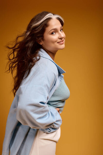 A young woman poses confidently in a studio, celebrating her unique features and style.