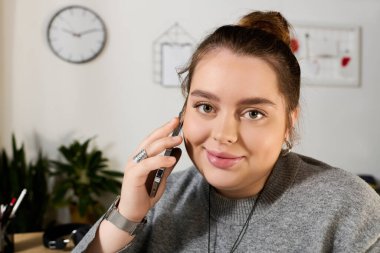 Ayrıca cüsseli bir kadın telefonuyla neşeli bir sohbet yapar. Parlak, karşılama odasında..