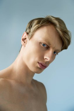 Genç bir adam modern erkeksiliği büyüleyici bir ifadeyle ve şık bir profille sergiliyor..