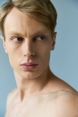 Çarpıcı özellikleri olan genç bir adam dikkat çekiyor dingin bir zemin üzerinde, inanılmaz bir cazibe yayıyor.