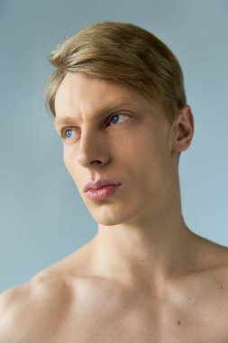 Genç, yakışıklı bir adam modern erkeksiliği, çekici mavi gözleri ve tanımlı özellikleriyle sergiliyor..