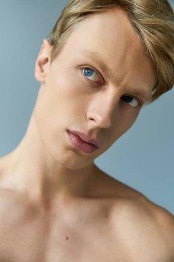 Genç, yakışıklı bir adam, modern erkekliği yumuşak bir ortamda çarpıcı bir ifadeyle somutlaştırıyor..